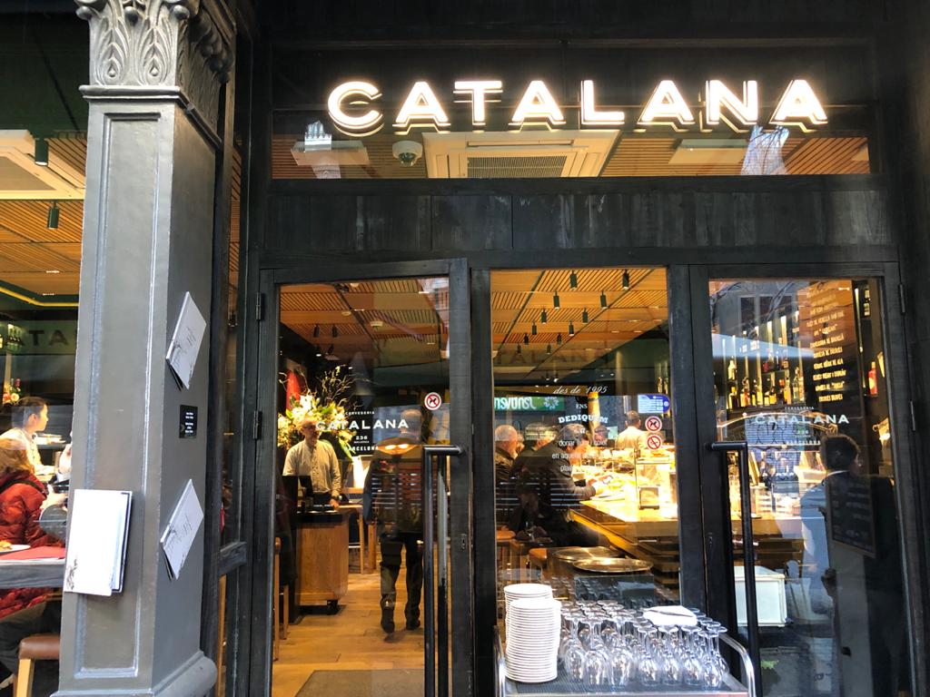 A busy late-night Barcelona tapas bar with a marble counter in the Eixample