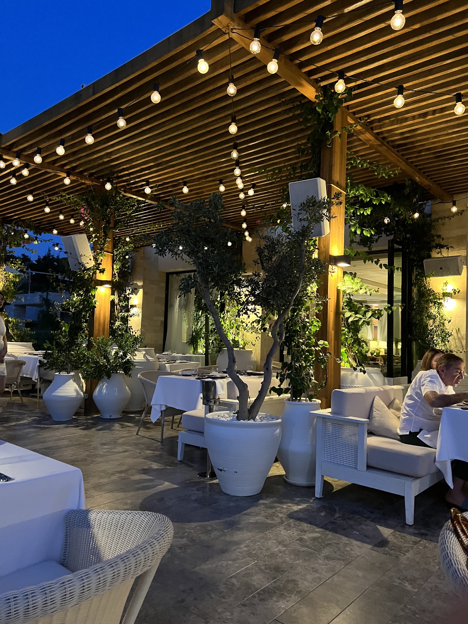 A polished Aegean terrace at a Yalıkavak marina restaurant in Bodrum set for a client dinner
