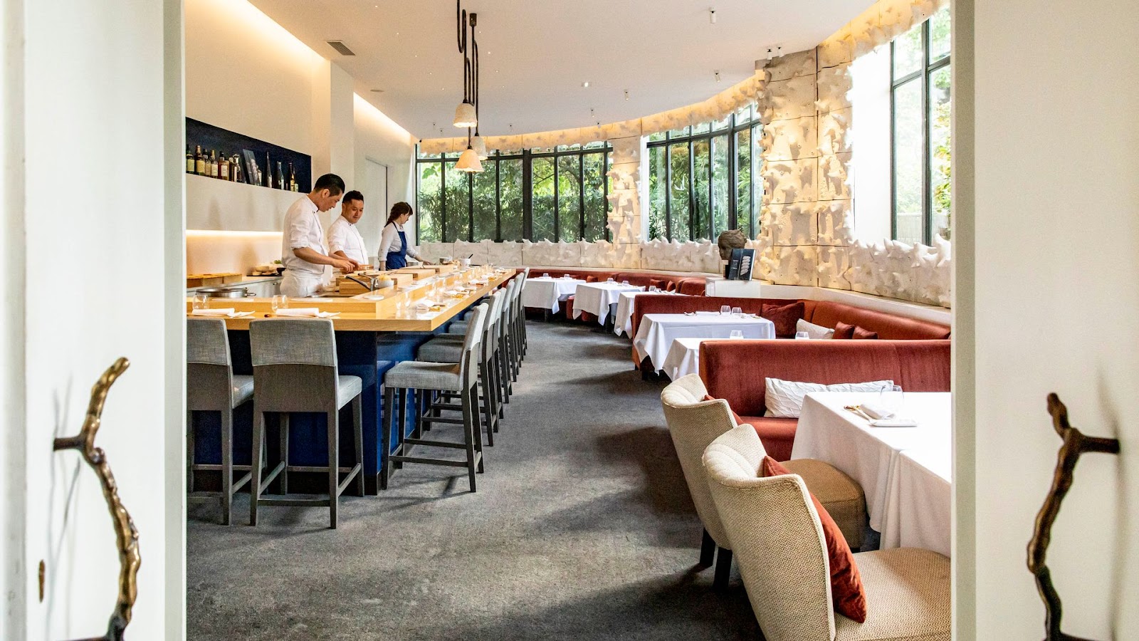 A chef shaping nigiri across a counter at a Michelin-starred sushi bar in Paris