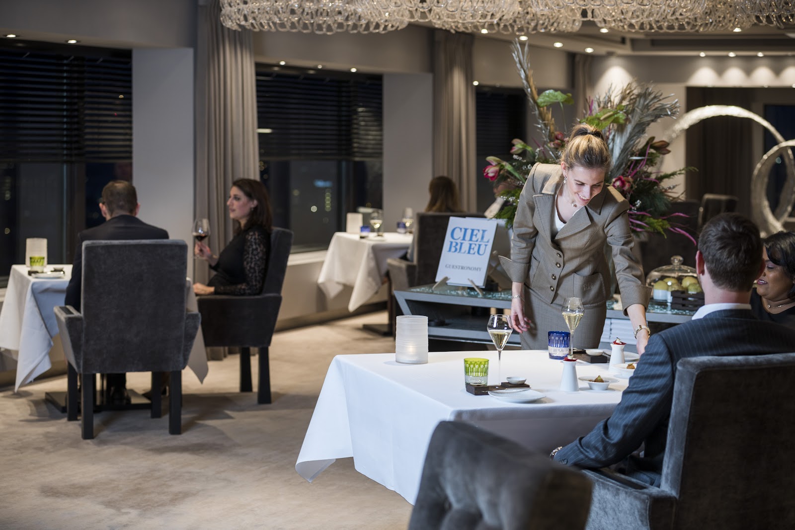 A window table with a city skyline view set for an anniversary dinner in Amsterdam