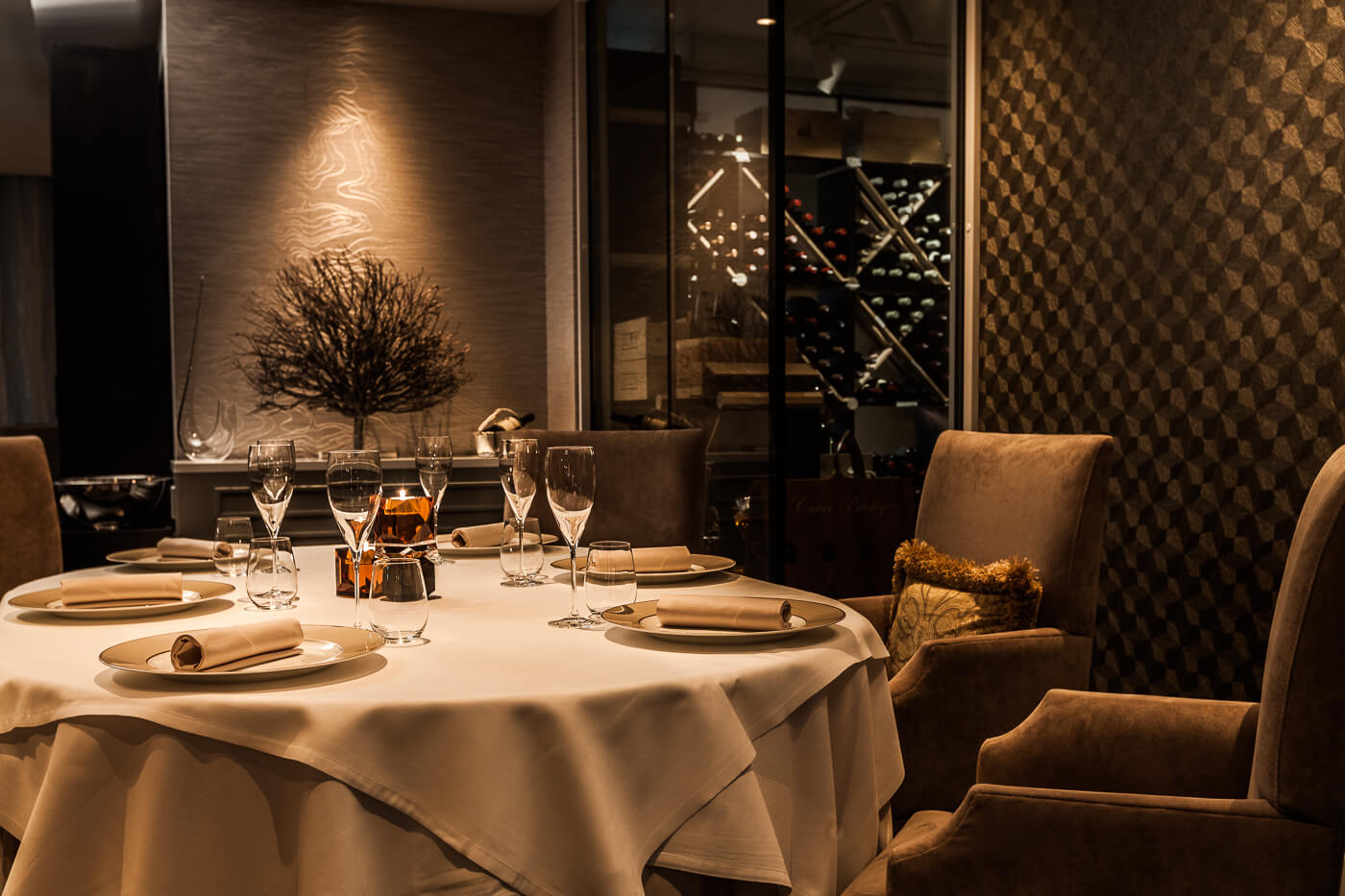 A candle-lit two-top set for a first date in a warm, low-lit Oslo dining room