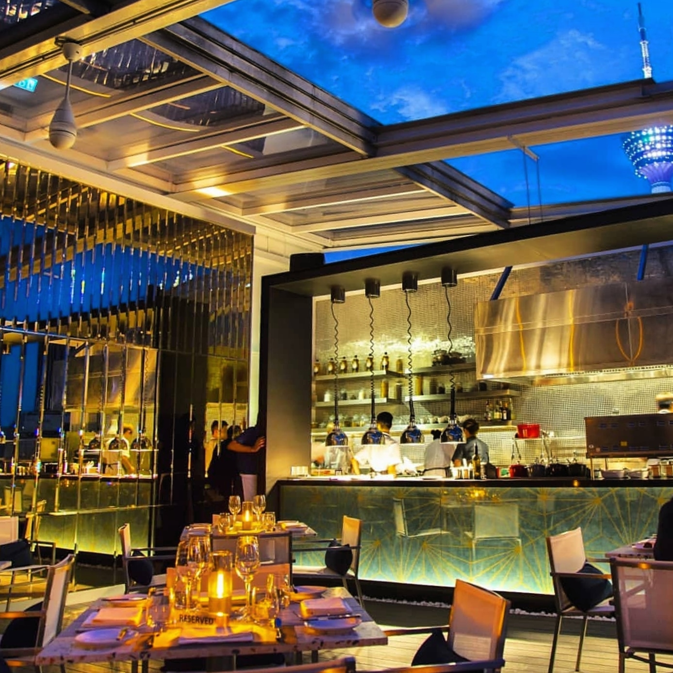 A rooftop first-date table at night with the Kuala Lumpur skyline and Petronas Towers