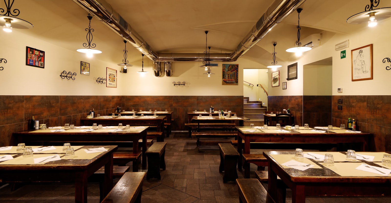 A communal wooden table set for a single diner in a Bologna osteria