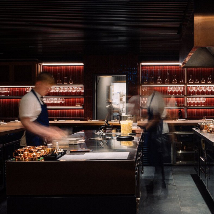 A fine-dining room high inside a Dubai hotel tower with city views at dusk