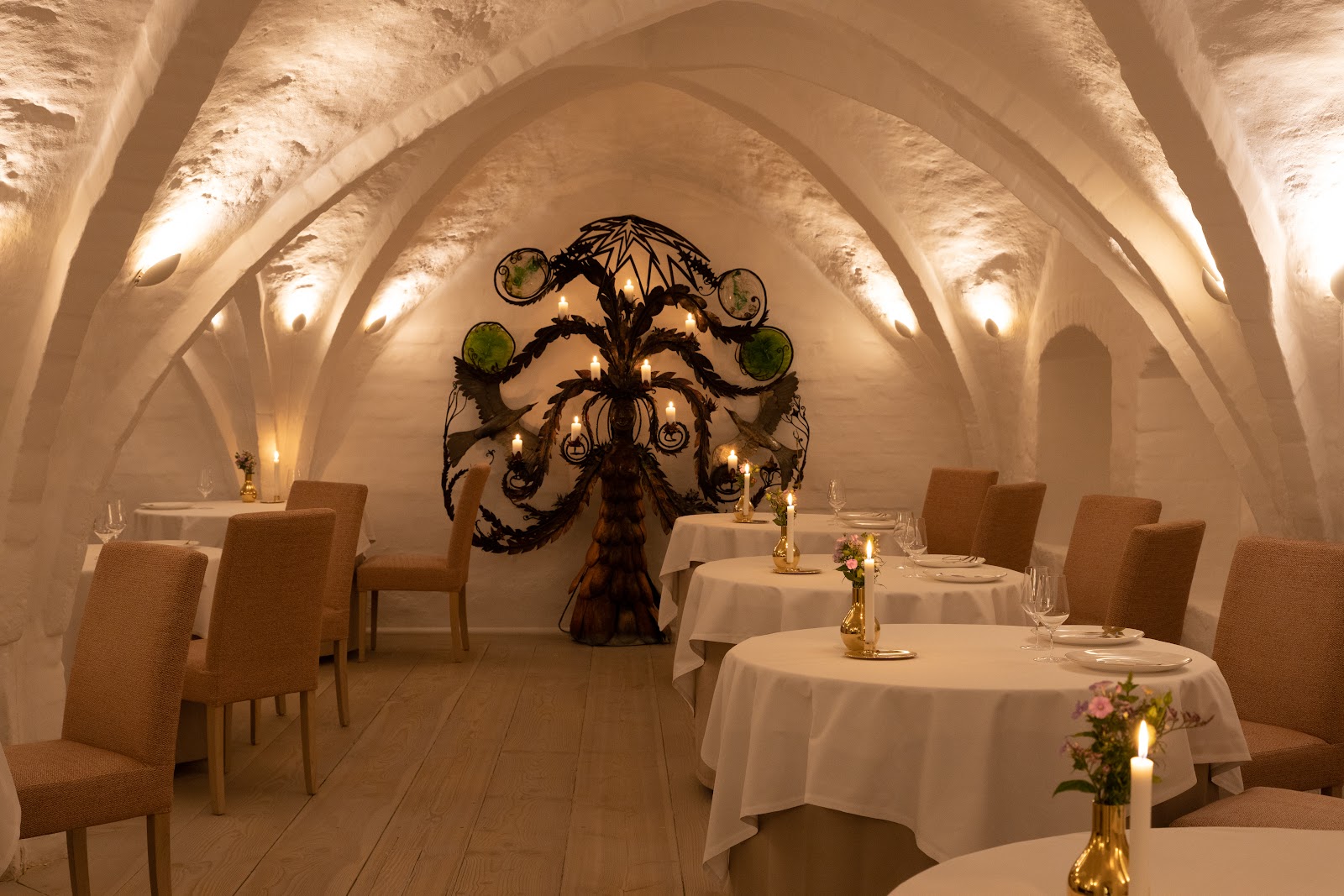 A candlelit two-top in an intimate Copenhagen cellar restaurant