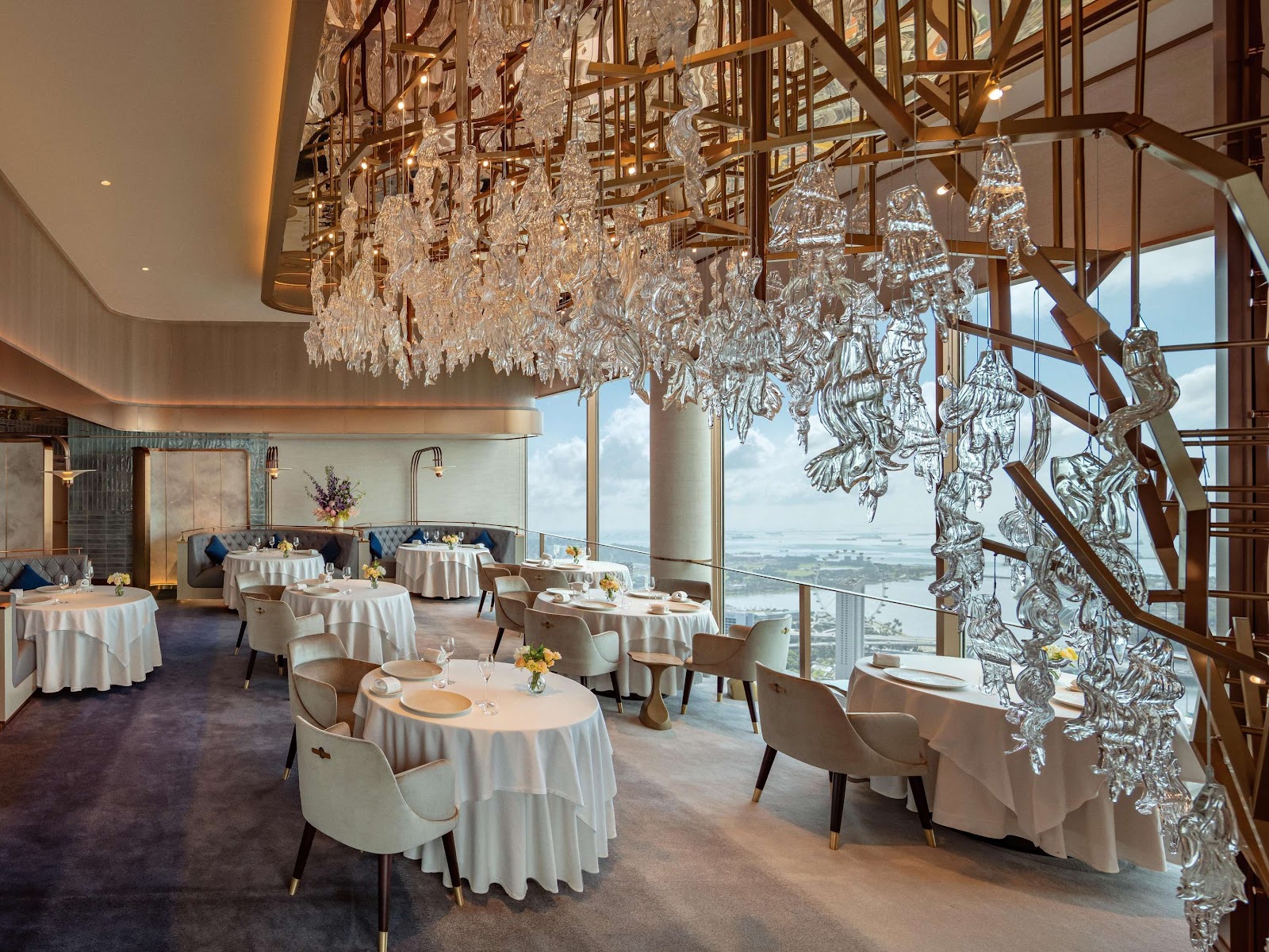 A fine-dining room inside a Singapore hotel tower with skyline windows