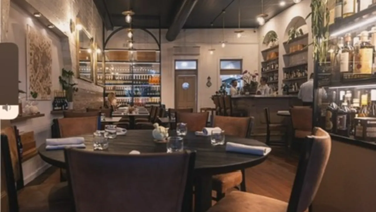 A sunlit Brisbane cafe table set with brunch plates and flat whites