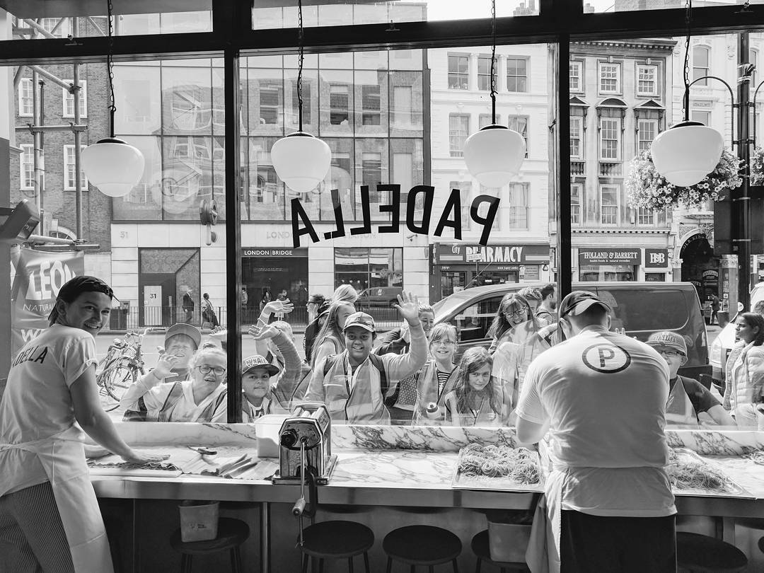 A marble counter at a no-reservations London restaurant with diners eating elbow to elbow