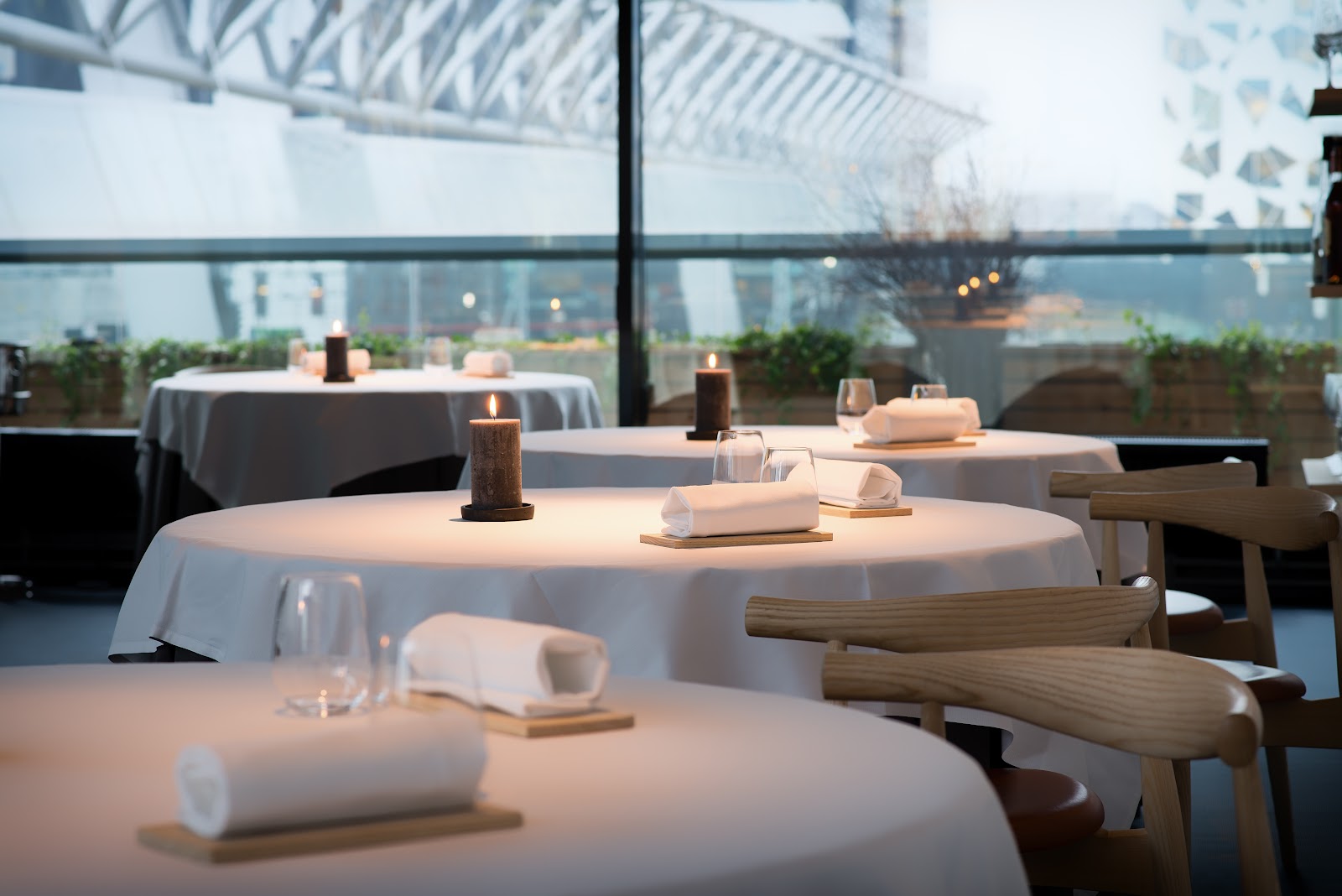 A chef plating at a kitchen counter seat in an Oslo tasting restaurant