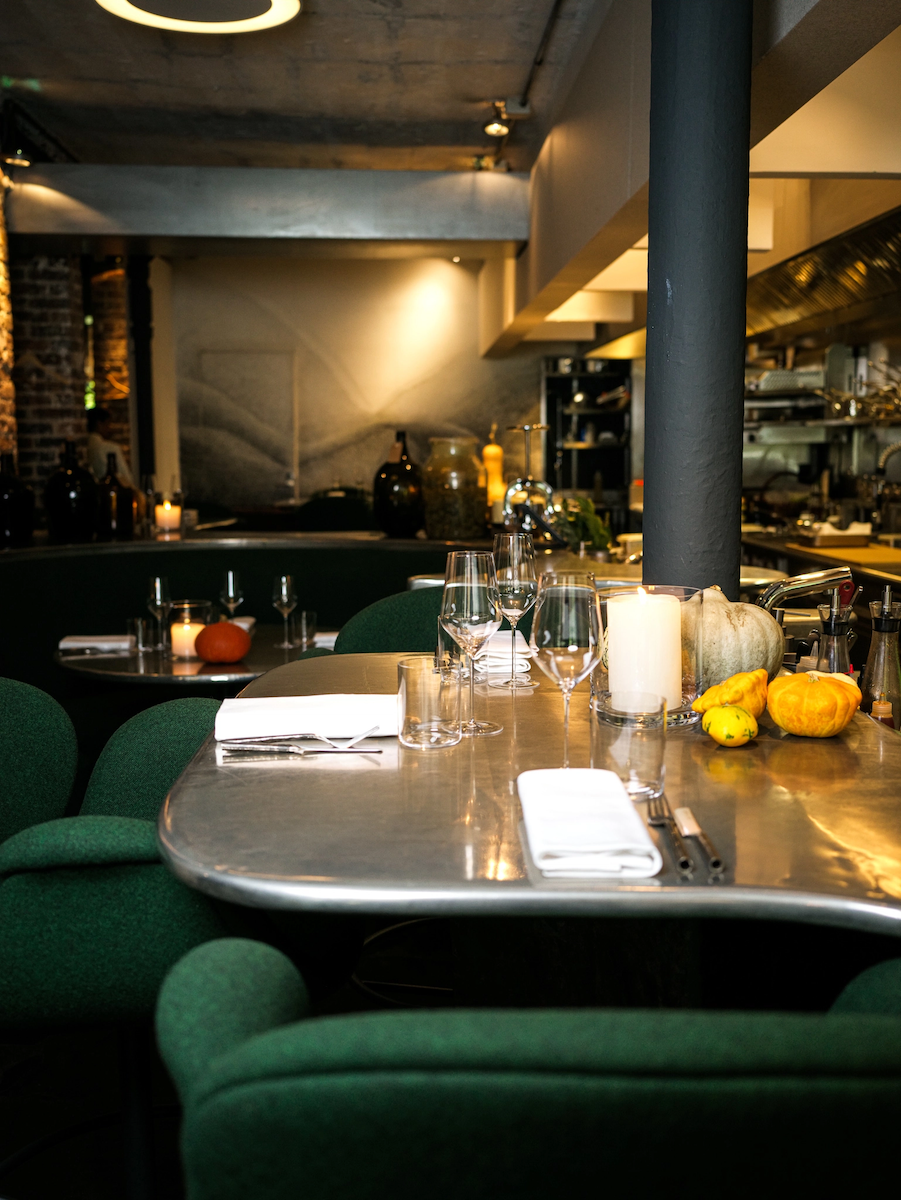 Diners at a chef's counter facing the open kitchen in a Paris restaurant