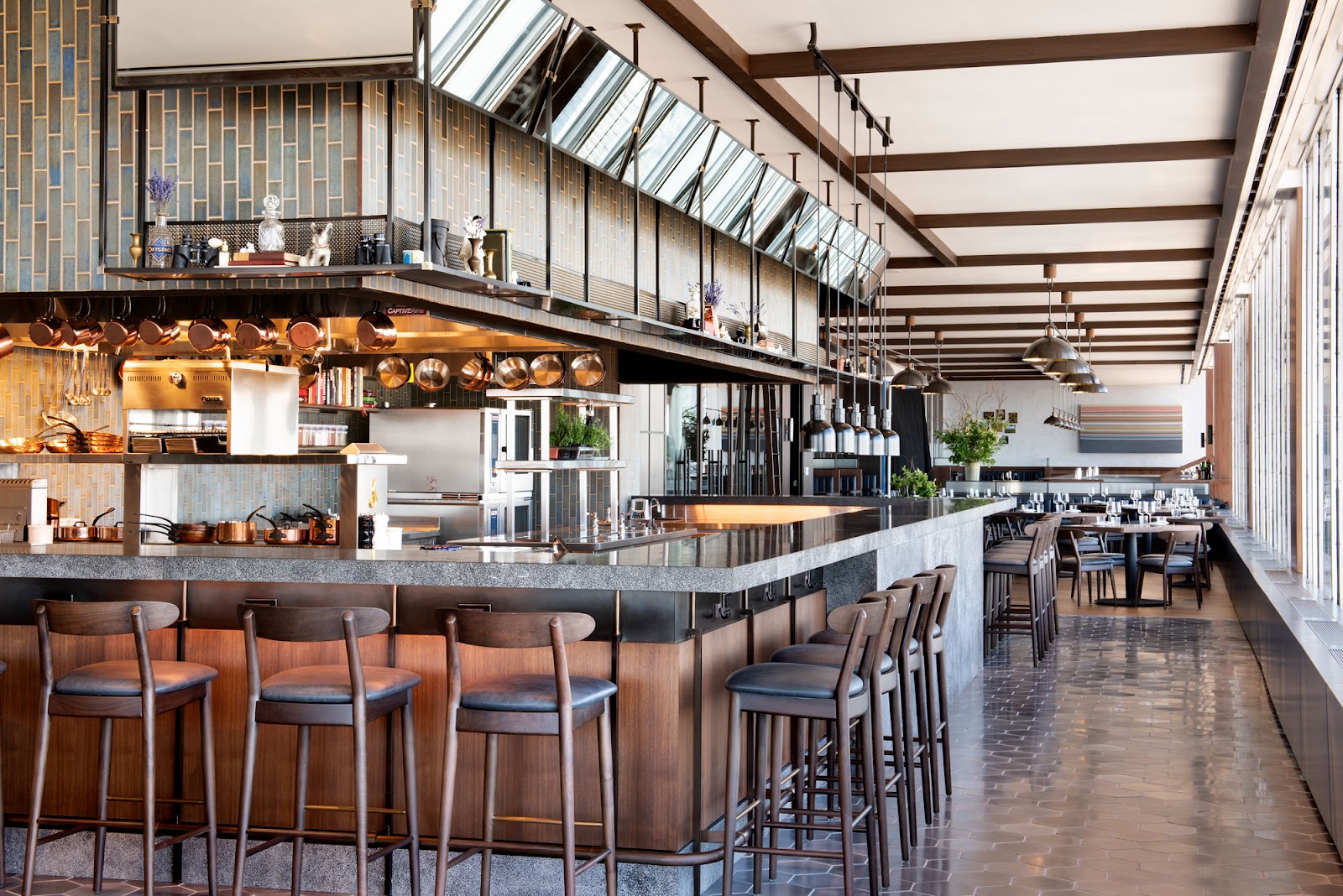 A rooftop restaurant terrace at dusk over the Manhattan skyline