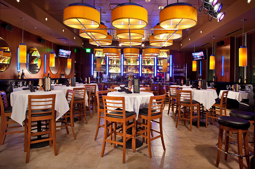 A private dining room in a Dallas steakhouse set for a group dinner with candlelight and wine
