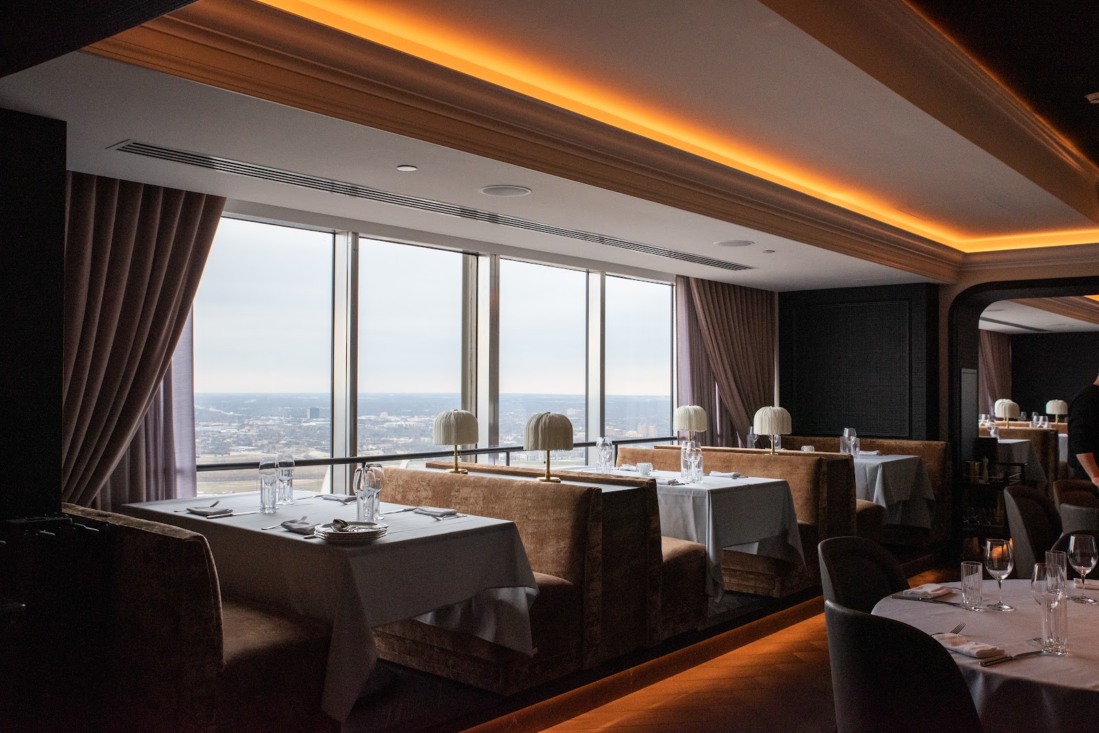 A Dallas steakhouse table set for a business dinner with a city view
