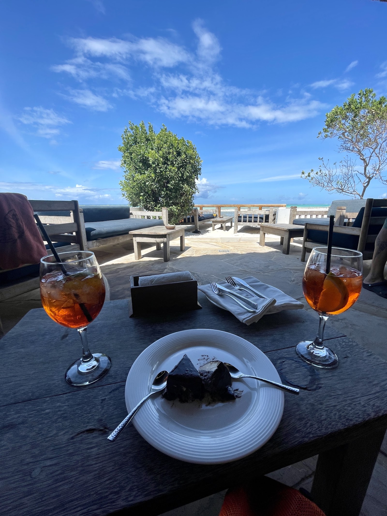A single seat at a Stone Town waterfront bar in Zanzibar, set for a solo diner