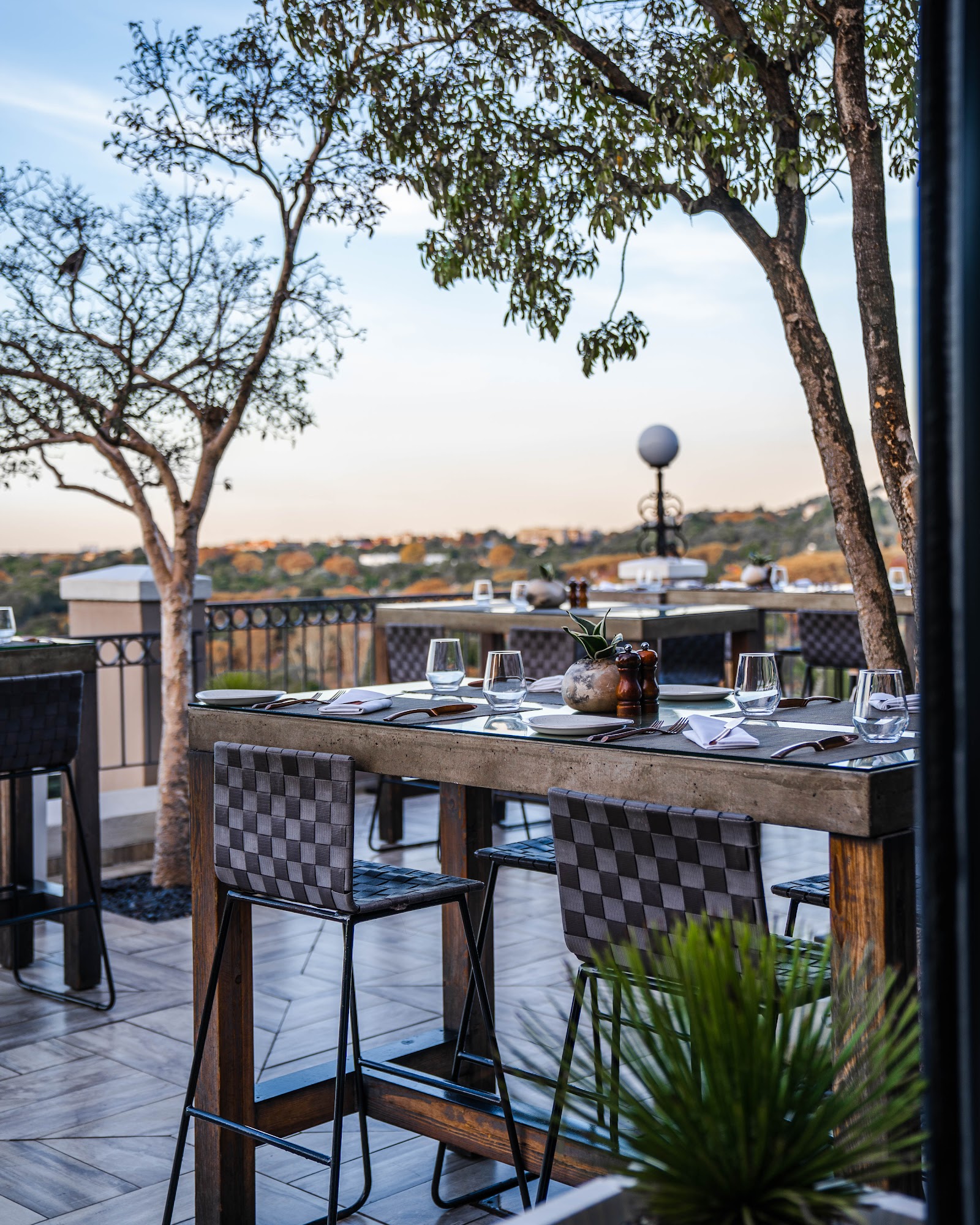 View over the Sandton skyline and Johannesburg's urban forest from a rooftop restaurant at dusk
