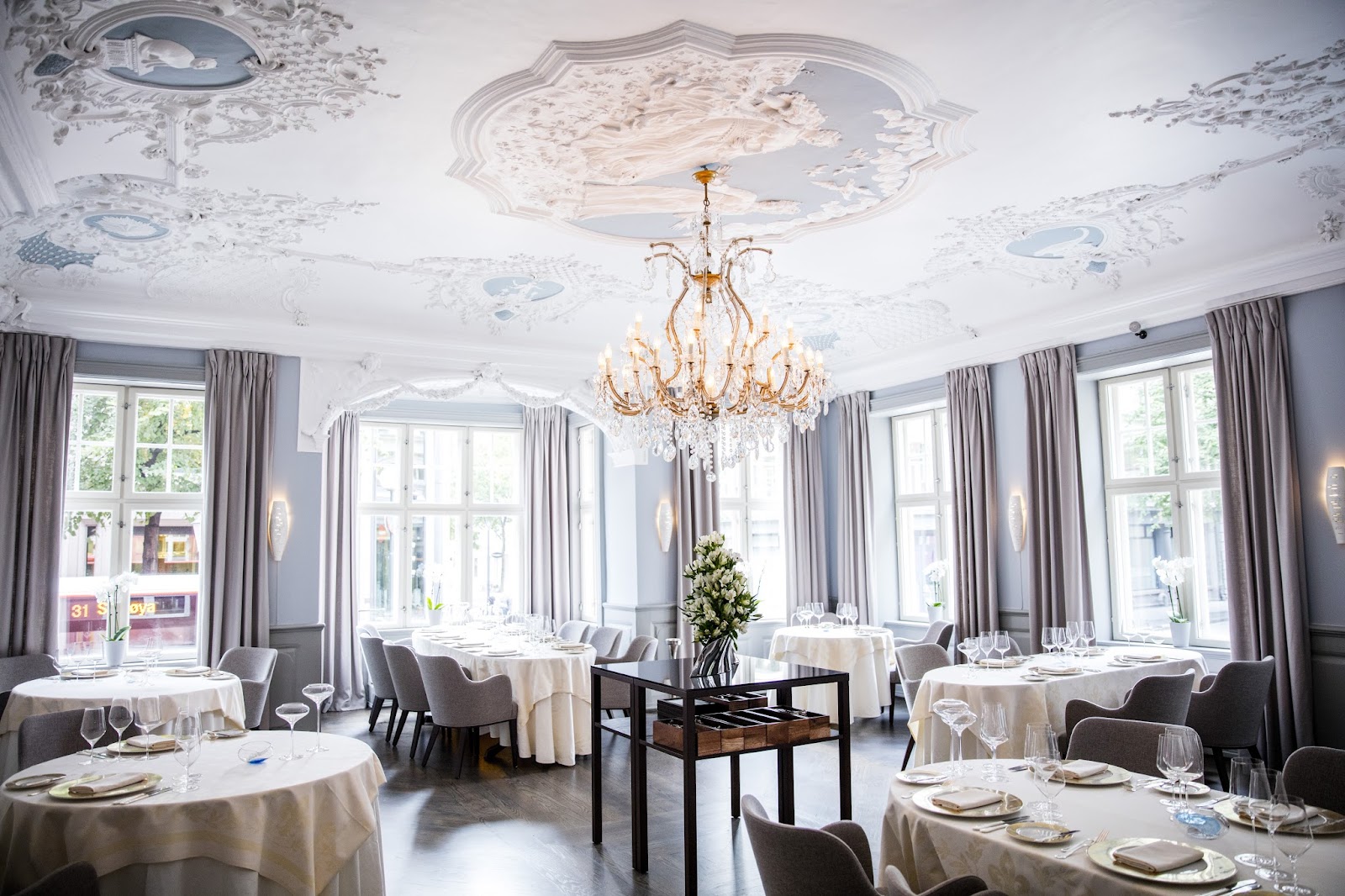 A set table for a client dinner in a low-lit, formal Oslo dining room